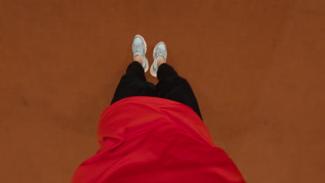 first-person perspective of hands, feet, and legs on a brown background