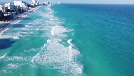 aerial view of blue caribbean sea and its waves breaking on beach in cancun hotel zone, mexico