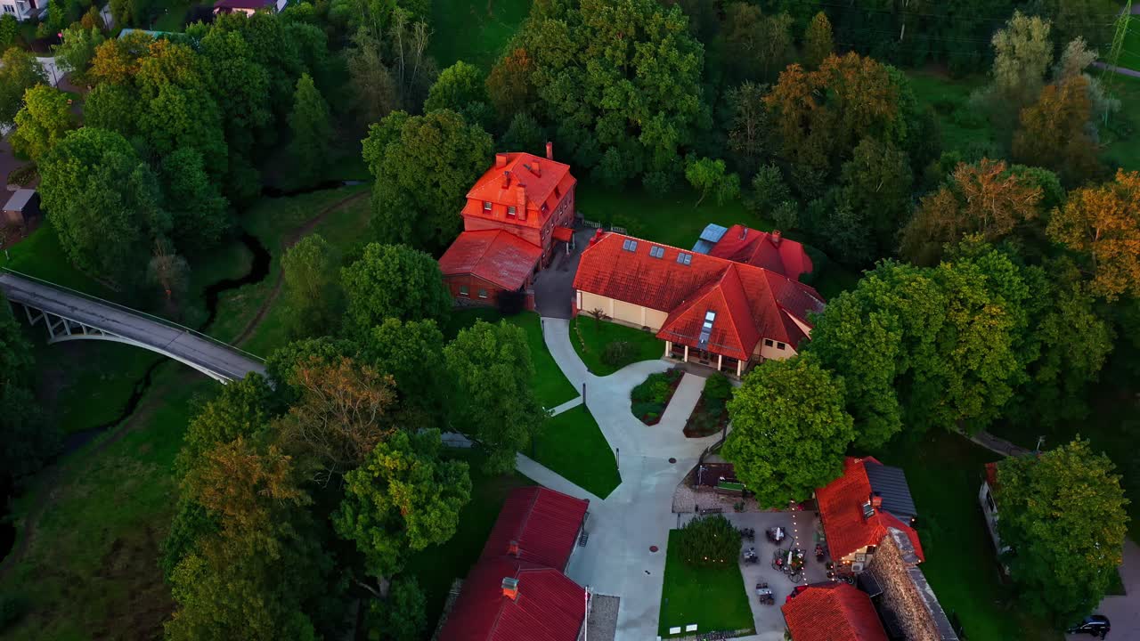 Valmiera, Lettonia, complesso del centro storico con edifici dal tetto rosso, alberi verdi e fiume tortuoso