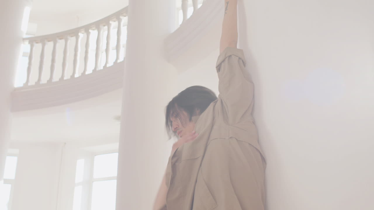 스튜디오에서 벽에 기대어 현대 남성 일본 댄서 훈련 댄스 동작의 밑면