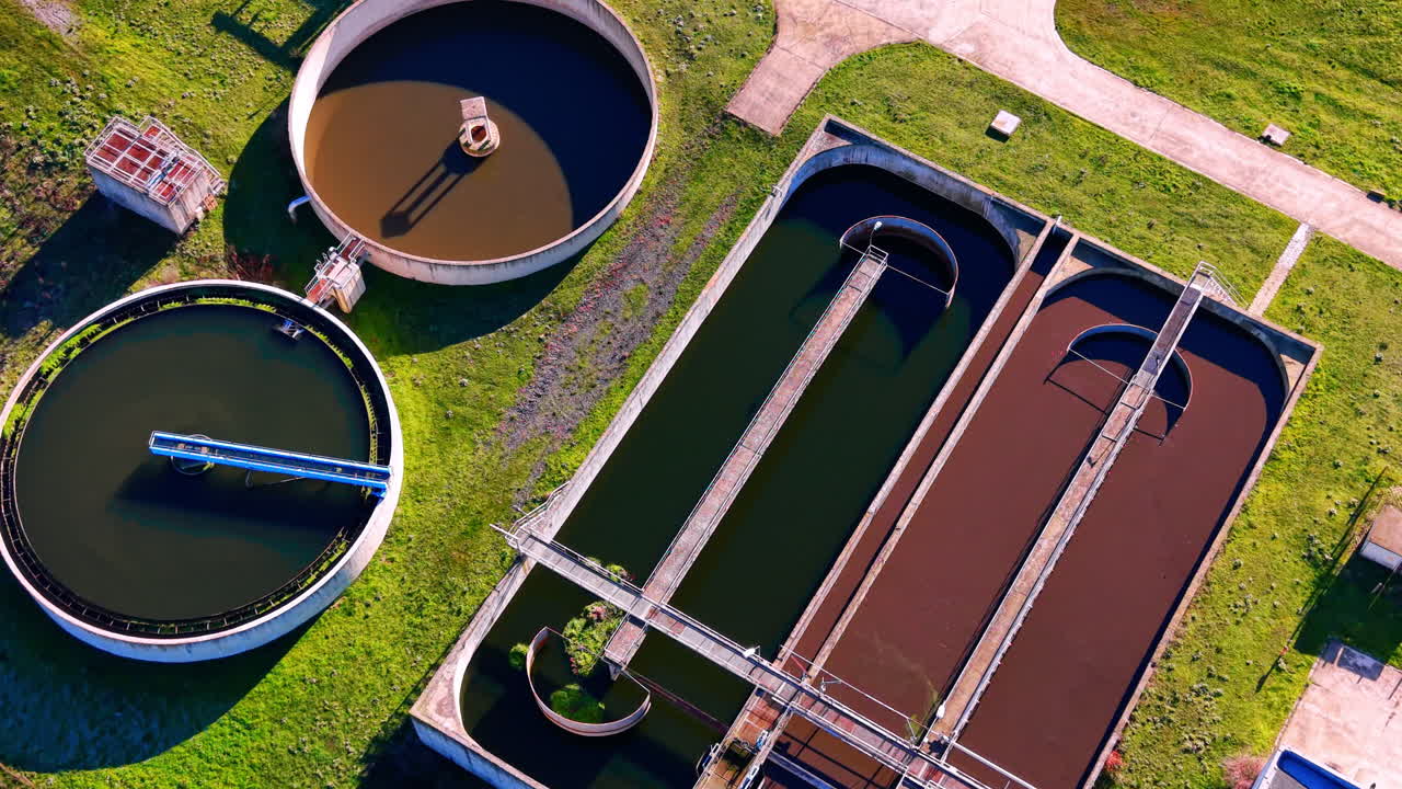 Various shapes of aeration and sedimentation tanks at a wastewater facility. Aerial view of rectangular and circular water treatment basins