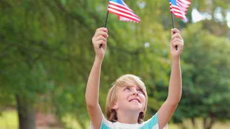 Kleiner-Junge-Schwenkt-Amerikanische-Flagge-Im-Park