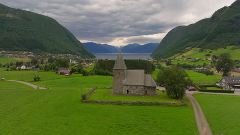 Drone-pullback-view-of-Hove-historic-parish-stone-church-in-Vik,-Norway