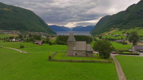 drone pullback view of hove historic parish stone church in vik, norway