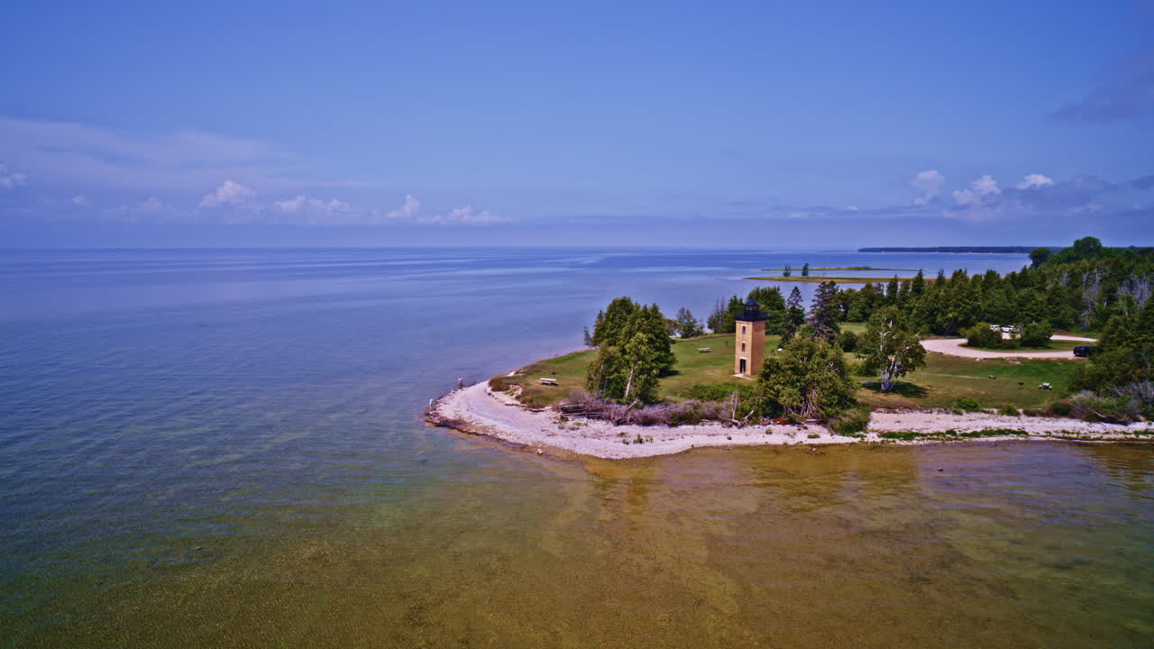 Drone shot panning flying right to left to reveal the lighthouse on the stonington peninsula in the U.P. of Michigan on beautiful summer day