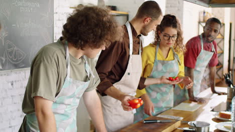 male chef giving cooking master class to young people