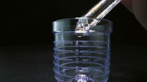 goteo de la vacuna antiviral en el matraz volumétrico de la ampolla