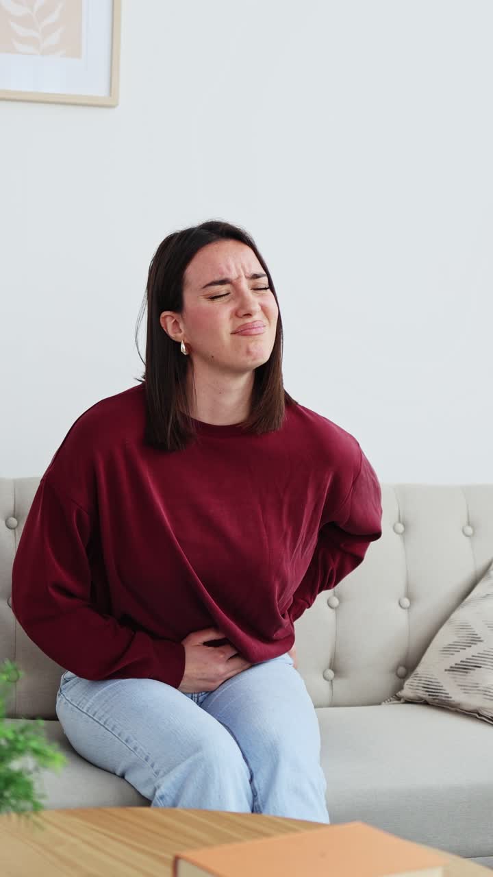 Young Woman Suffering from Stomach Ache and Abdominal Pain at Home