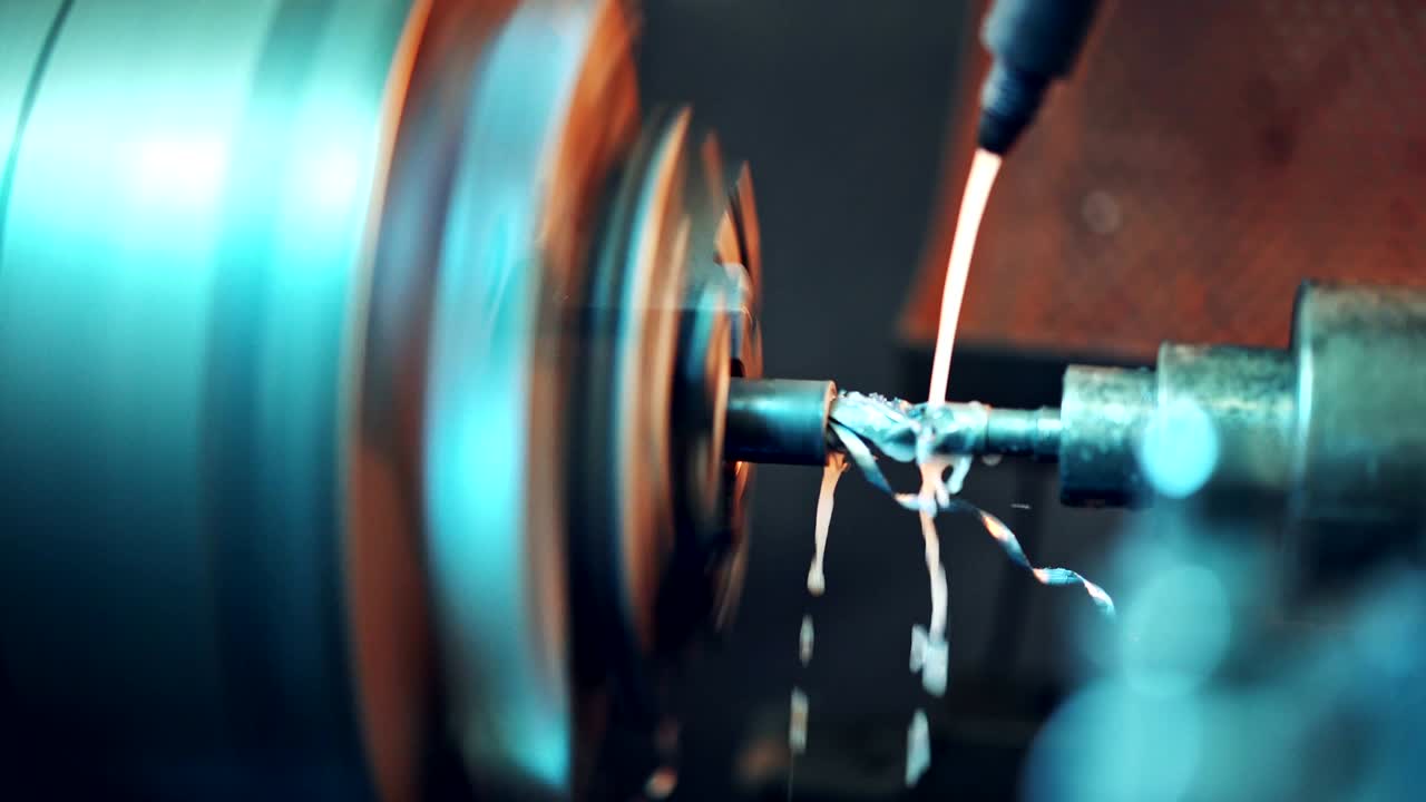 un torno procesa la pieza de trabajo metálica con líquido de enfriamiento que enfría la herramienta y aumenta la productividad del proceso.