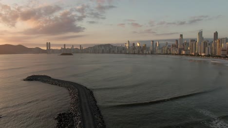 Tall-Buildings-Next-to-the-Sea,-Golden-Hour-Aerial-View-Forward-Flight