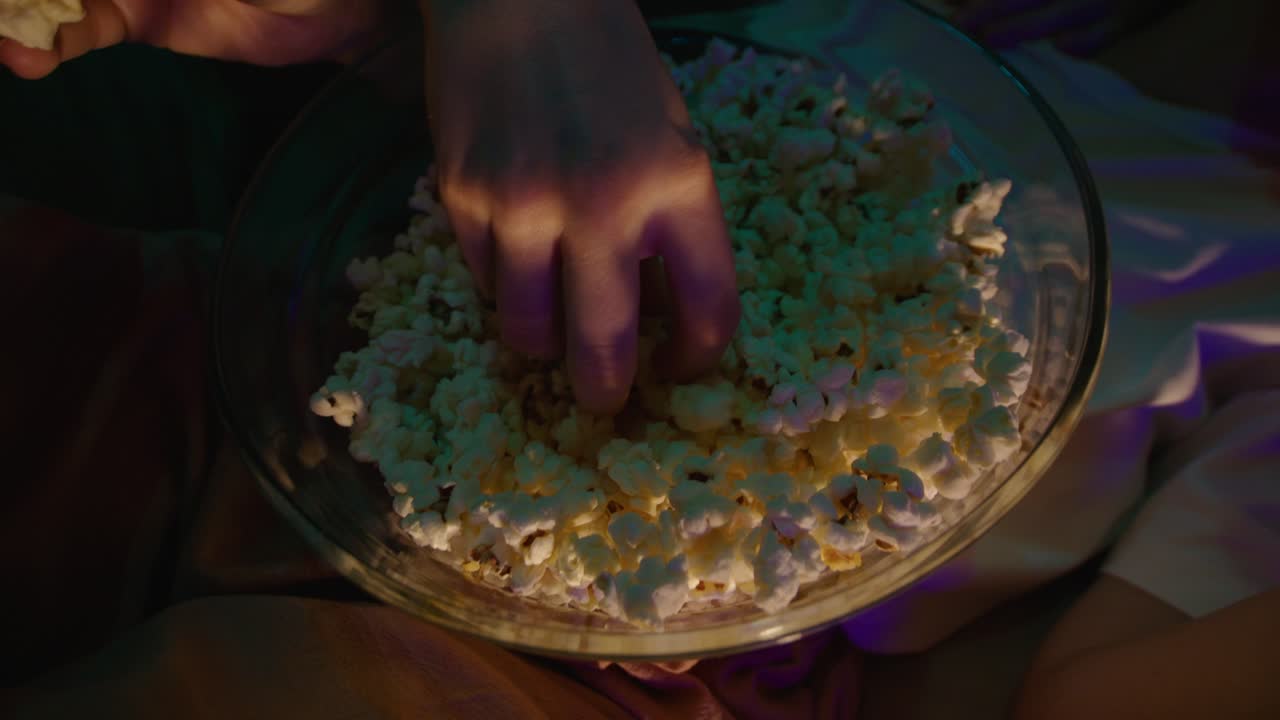 Person Eating Popcorn at Night