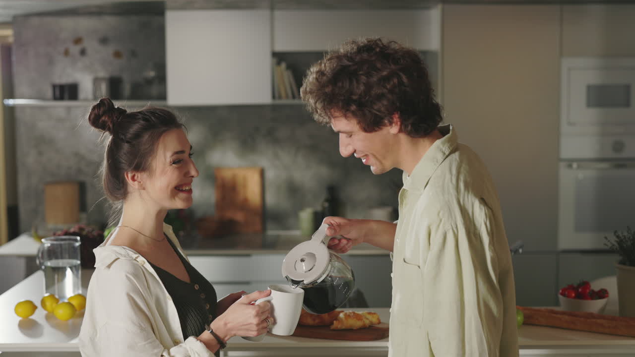 Couple pouring morning coffee in a modern kitchen