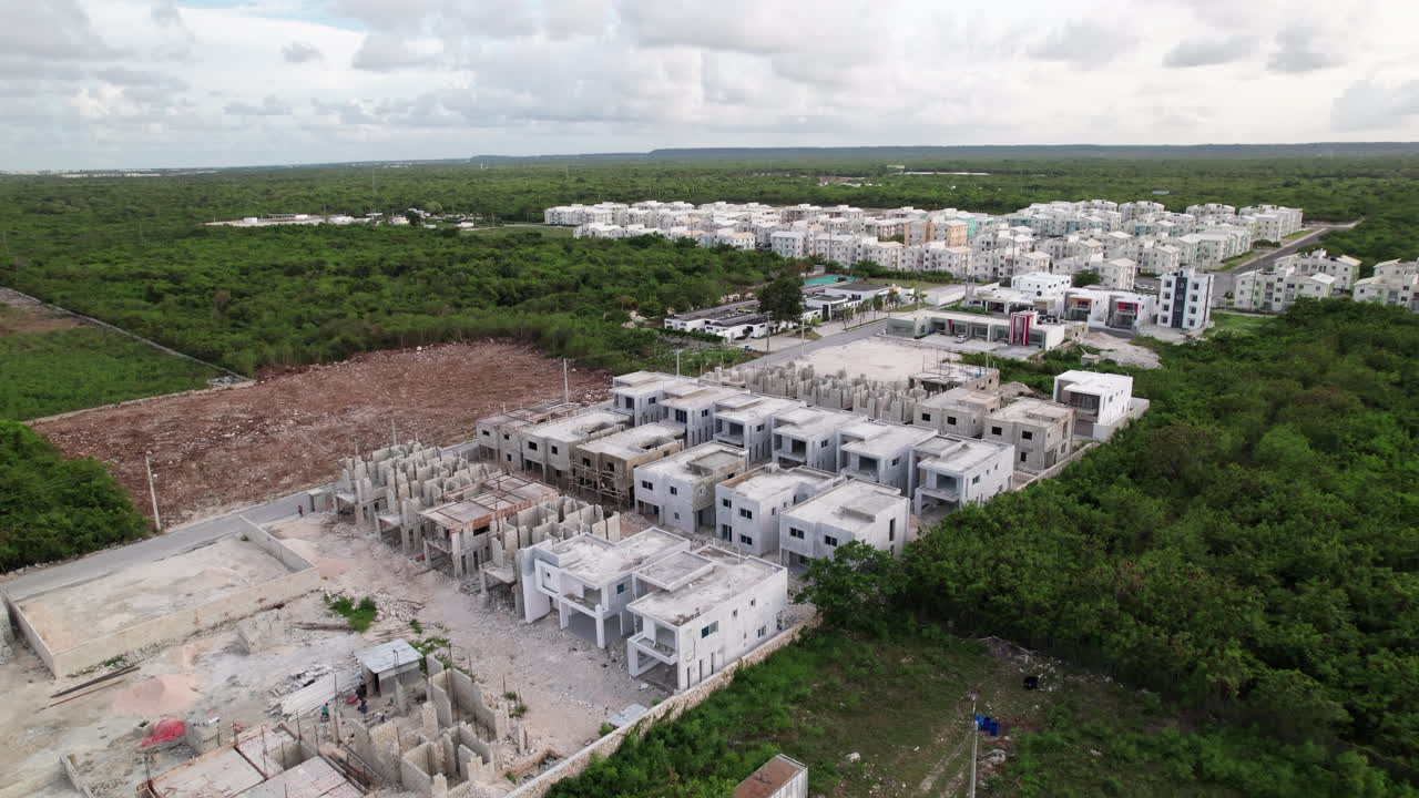 vista aérea sobre el nuevo desarrollo de la construcción de condominios mar de plata con ciudad las cayenas en el fondo en punta cana