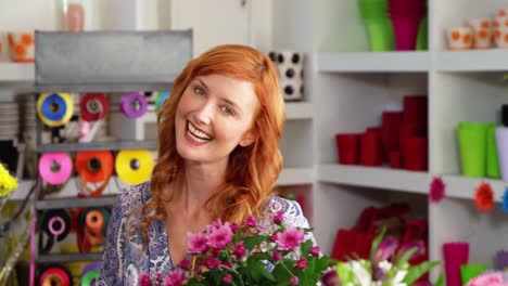 Beautiful-female-florist-smelling-bunch-of-sunflower