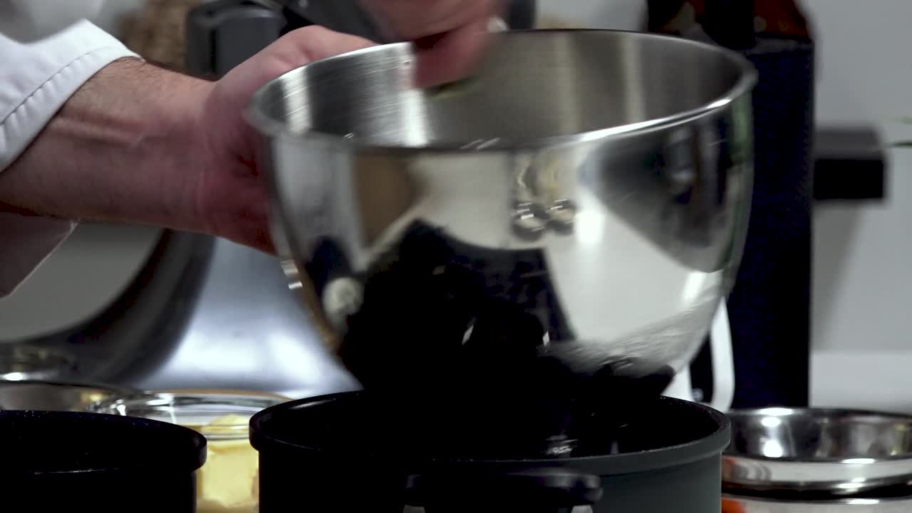 In a cozy kitchen, someone skillfully whisks together various ingredients in a large mixing bowl, preparing for a forthcoming delicious dish. The ambiance is warm
