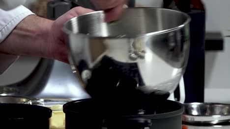 in a cozy kitchen, someone skillfully whisks together various ingredients in a large mixing bowl, preparing for a forthcoming delicious dish. the ambiance is warm