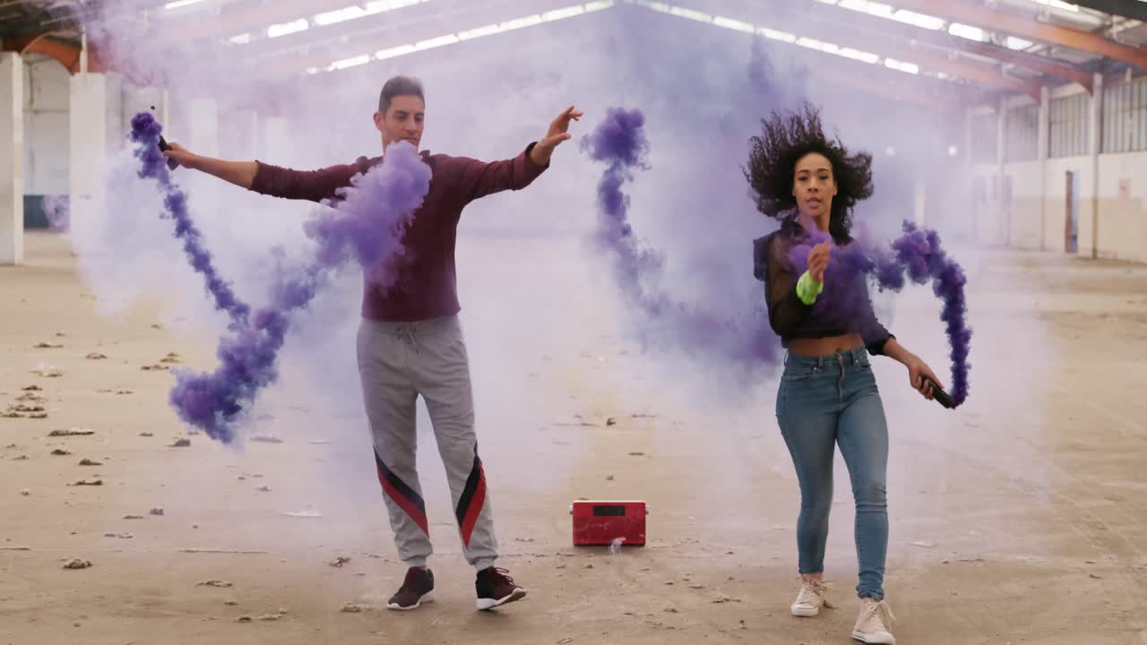 bailarines en un almacén vacío con una granada de humo