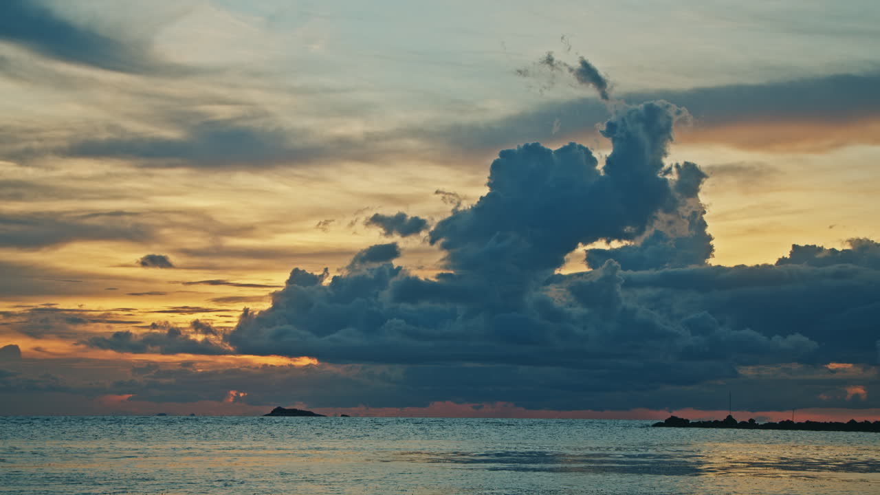 극적인 구름과 함께 바다 위에 해가 지는 것