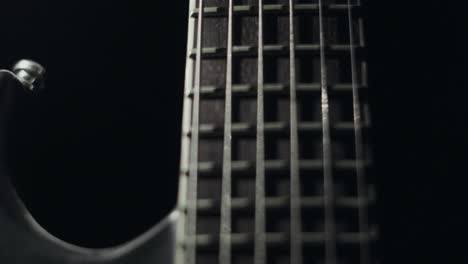 light revealing guitar strings in complete darkness