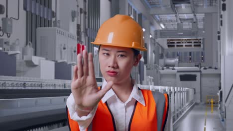 close up of asian female engineer with safety helmet disapproving with no hand sign at pharmaceutical factory, vaccine production facility