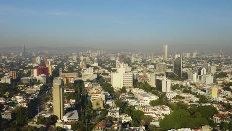 drone flies backwards away from tall buildings in guadalajara, mexico