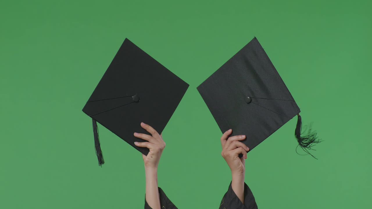 Laureati che lanciano i cappelli di laurea