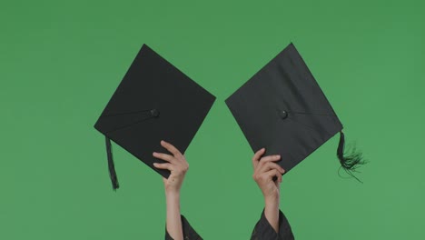 graduates holding up graduation caps