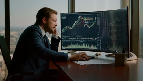 businessman analyzing financial data and stock market charts on computer monitor in office