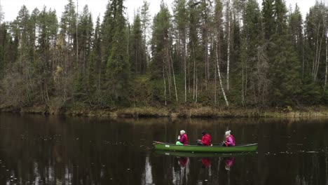 imágenes de drones de 3 adultos en canoa en el parque nacional de oulanka