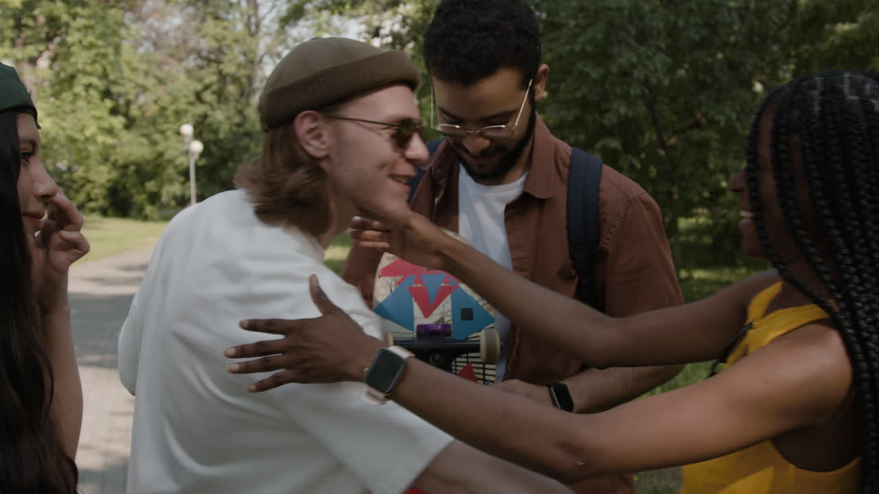 Young Adults Socializing with a Skateboard in a Park