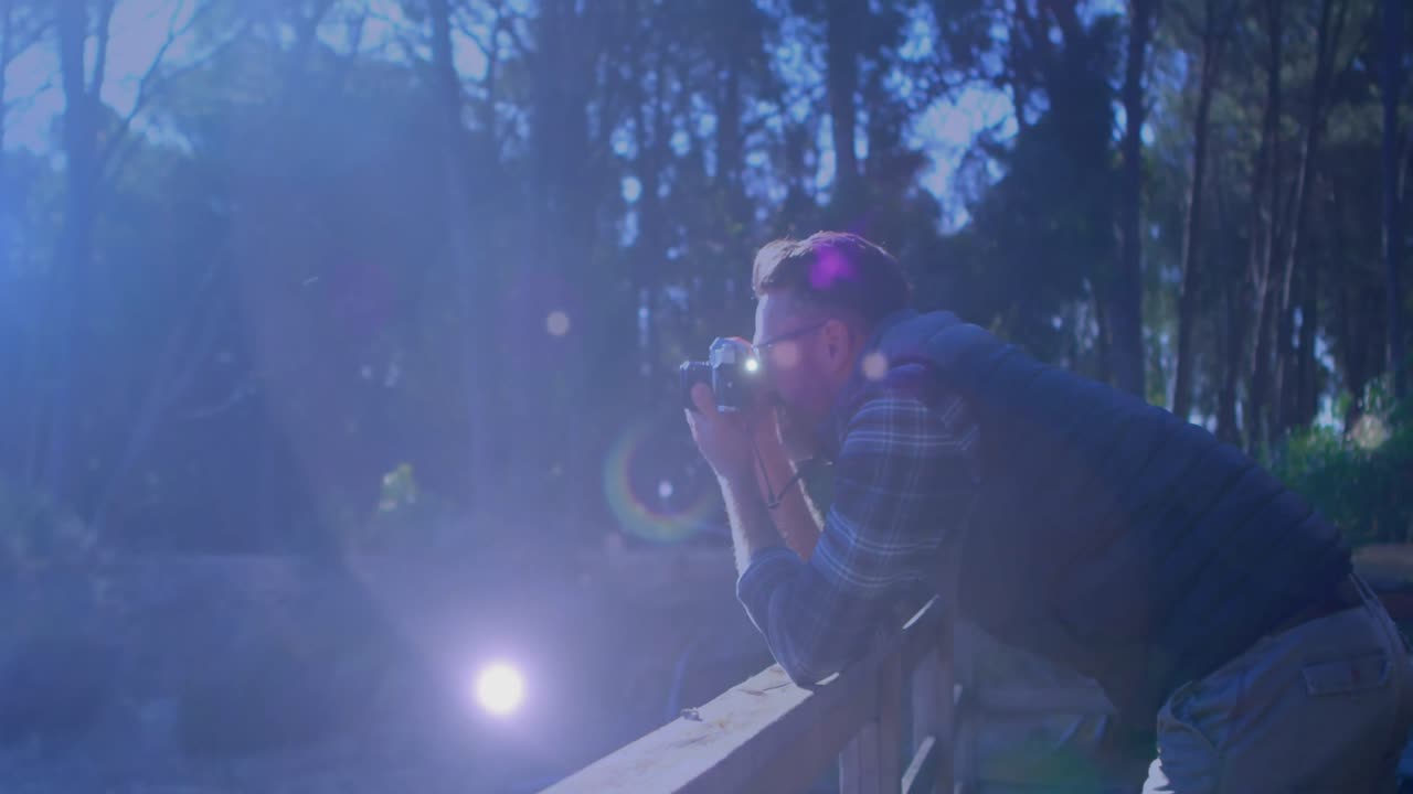puntos de luz contra un fotógrafo caucásico haciendo clic en imágenes con una cámara digital al aire libre