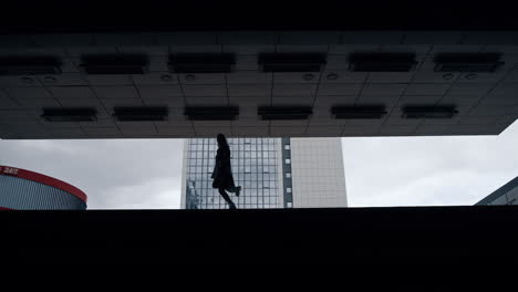 silhouette female person jumping in dark underground station or parking.