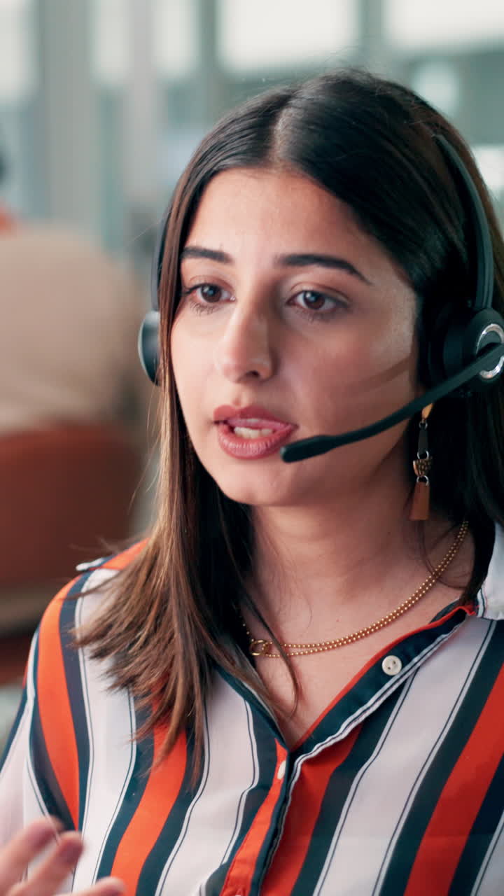 Ung kvinne med headset som snakker i kundesenter