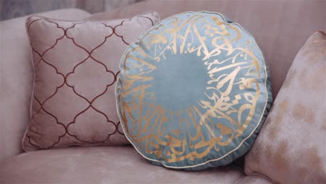 arab man placing a blue cushion on sofa. static shot. close up.