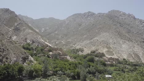 Panshir-valley-with-green-foliage-and-tall-mountains,-handheld-view