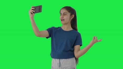 Happy-Indian-teenage-girl-shooting-a-vlog-Green-screen