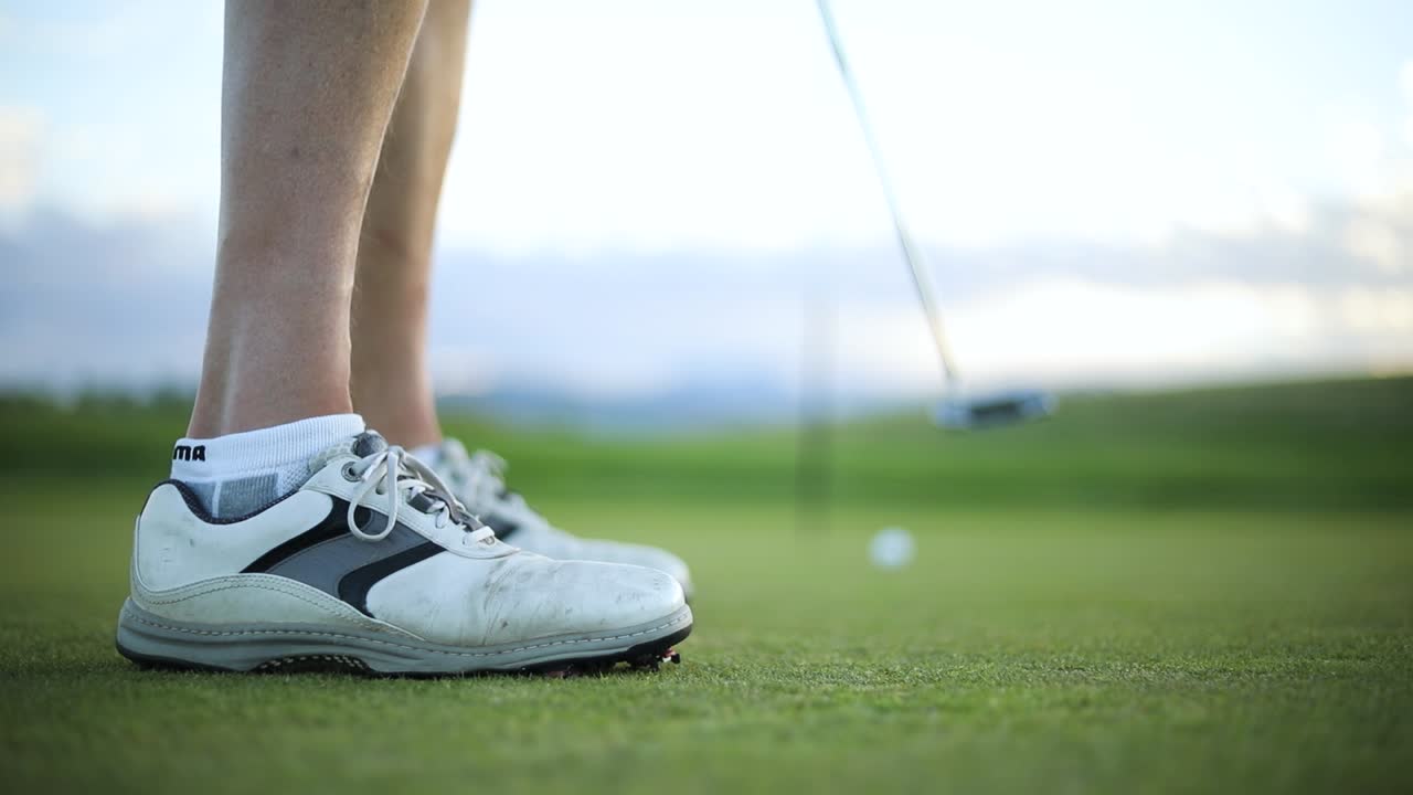 퍼팅 그린에서 퍼팅을 하는 남자의 슬로우 모션 샷