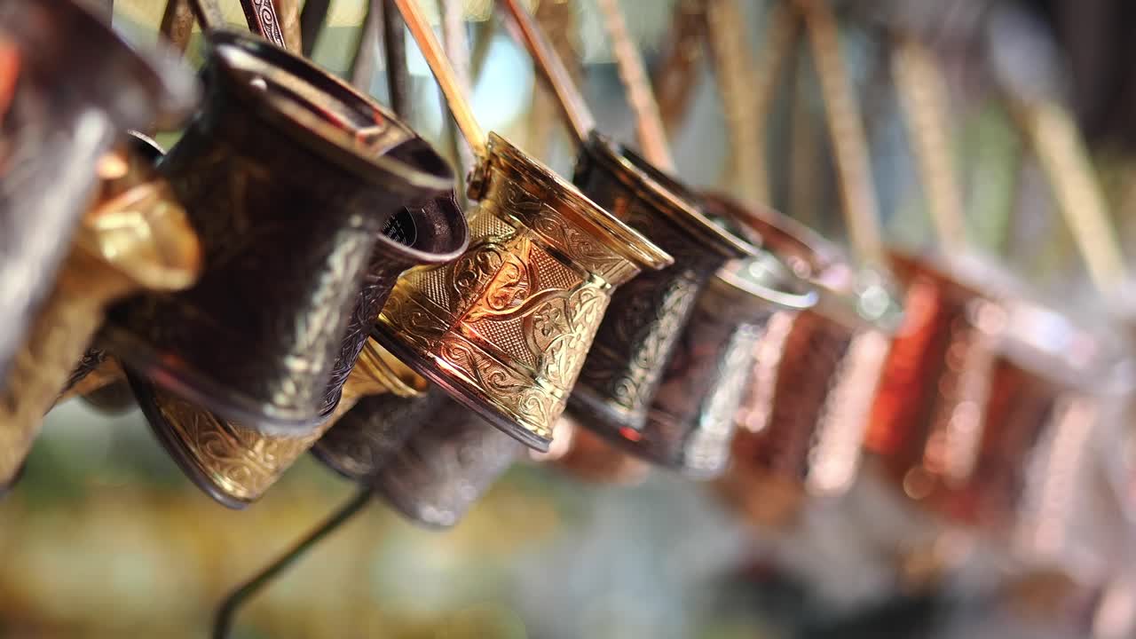 Caffettiere tradizionali in metallo incise, esposte in fila