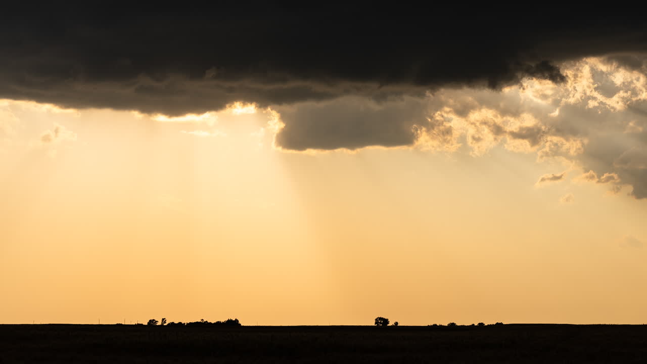 Sunset Through Storm Clouds Over a Field