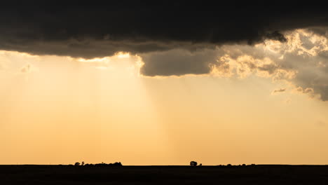 sunset through storm clouds over a field