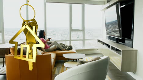 animation of golden key and house over biracial woman in living room