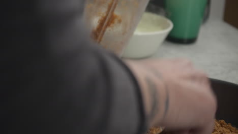 primer plano: corteza de tarta de queso vertida de la licuadora en un molde desmontable