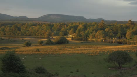 Wunderschönes-Sonnenlicht-Erstreckt-Sich-über-Die-Grüne-Wiese-Bis-Zum-Heruntergekommenen-Haus-Am-Fluss