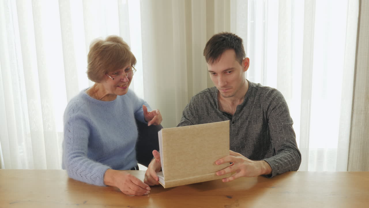abuela y nieto mirando un viejo álbum de fotos