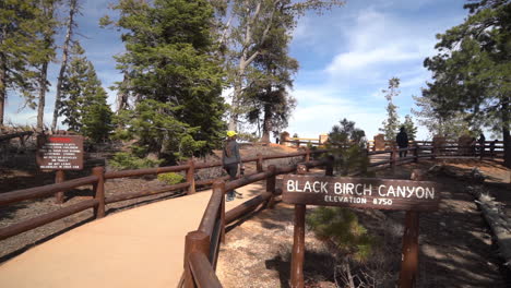 Señal-Del-Mirador-Del-Cañón-De-Abedul-Negro-En-El-Parque-Nacional-Bryce-Canyon,-Utah,-EE.UU.-Y-Una-Mujer-Caminando-Por-El-Sendero