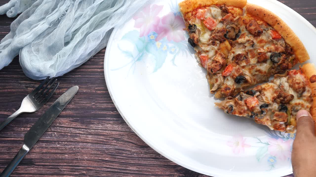 la mano tomando una rebanada de pizza
