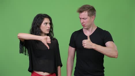 studio shot of young couple having different decisions together