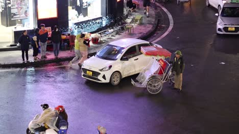 pedestrians and vehicles navigating a wet urban road.