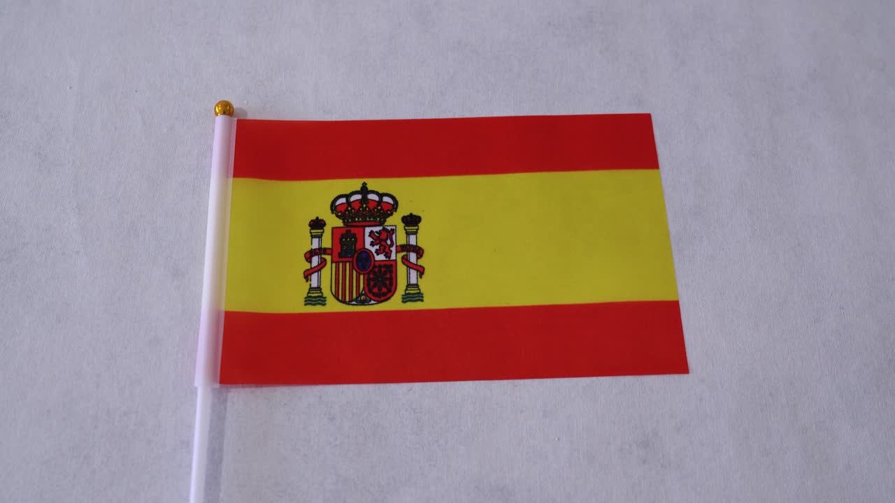 Spaniens flagga närbild på vit bakgrund. Spanska nationalflaggan.