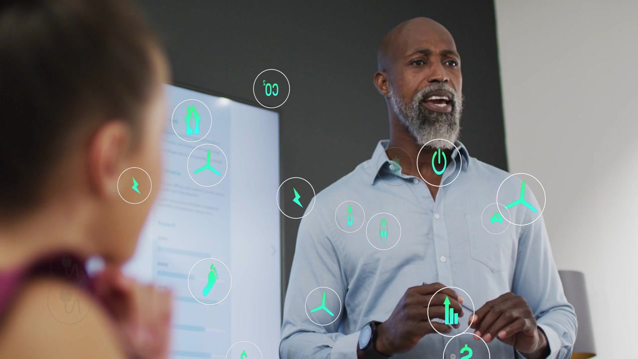 Male presenter gesturing during business meeting causing teal icons clustering illustrating data